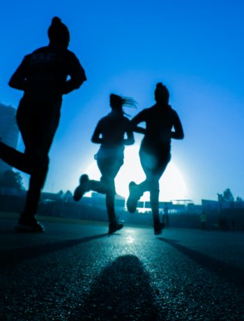 3 women running as it is getting dark outside