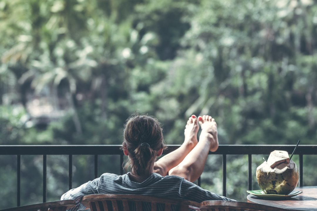 woman relaxing on balcony looking out at trees