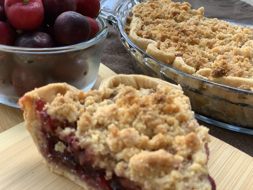 Cherry Crumble Pie with bowl of cherries