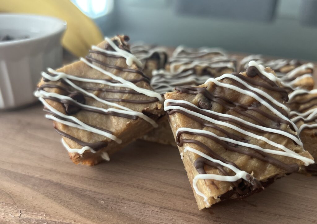 Front view of peanut Butter Banana Brownies on a wood cutting board.