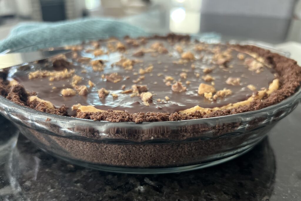 Side view of Peanut Butter Cream Pie on a black countertop.