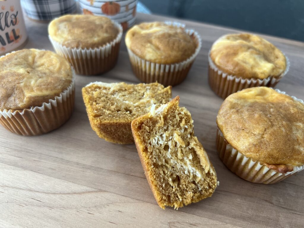 Pumpkin Cream Cheese Muffins on a wood cutting board.